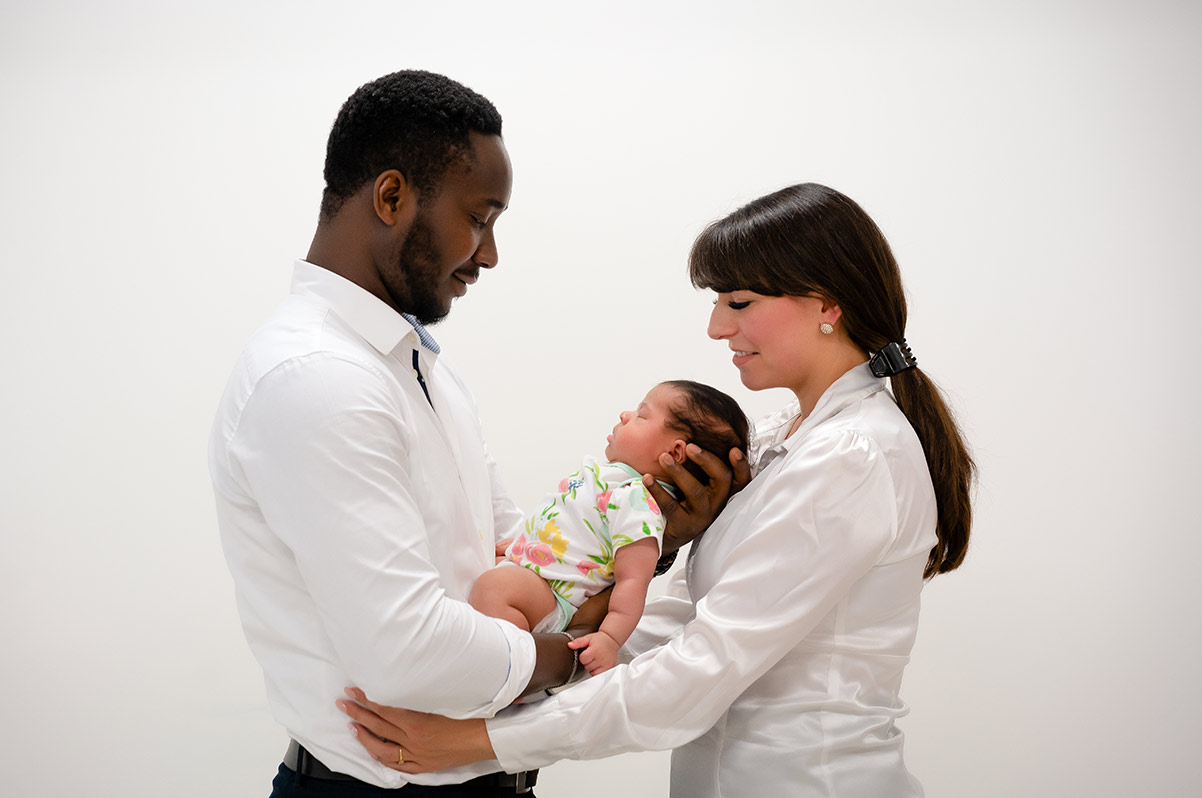 Mutter-und-Vater-halten-das-Neugeborene-beim-Neugeborenen-Fotoshooting-im-Fotostudio-Donna-Bellini