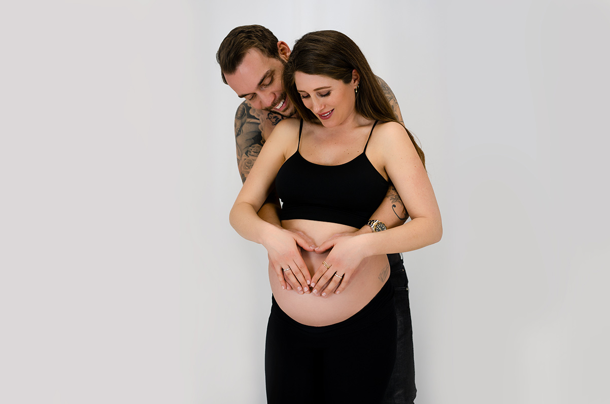 Schwangere Frau mit ihrem Mann beim Babybauch Shooting